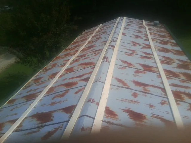 Rusted metal roof panels with new wood purlins before replacement — Storm Damage Roof Repair in Clarkia by Roofing Brothers