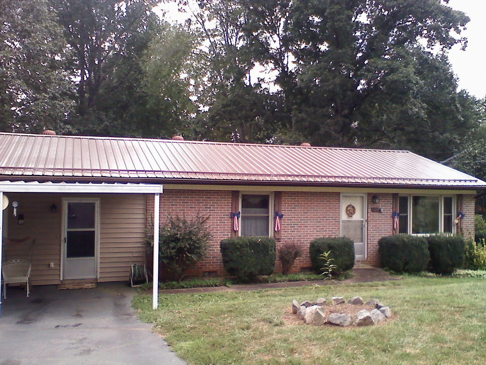 Bronze metal roof and carport on a brick ranch home — Roof Repair work by our crew in Clarkia